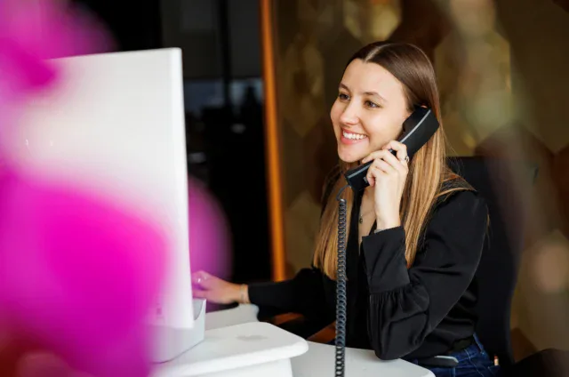 A woman taking a phone call in an office.